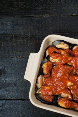 Siyah arka planda domates salçası ile çiğ midye, pişirme.