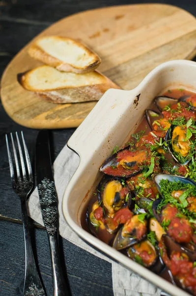 Kişniş ve Parmesan ile domates soslu pişmiş midye.