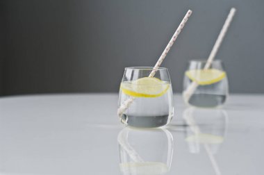 limon ve saman ile berrak su bardağı.