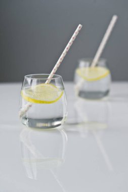 limon ve saman ile berrak su bardağı.