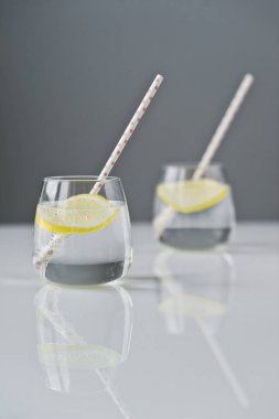 limon ve saman ile berrak su bardağı.
