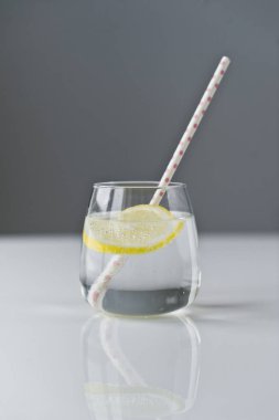 limon ve saman ile berrak su bardağı.