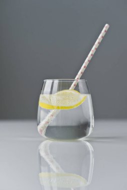 limon ve saman ile berrak su bardağı.