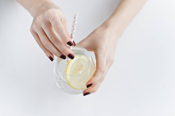 руки держа стакан чистой воды с лимоном
.