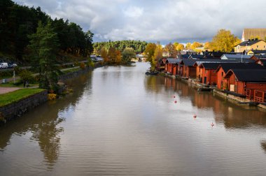 Klasik ahşap kırmızı evler ve nehirdeki yansımaları. Porvo