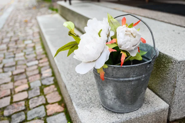 Decorative bucket with peonies on the stairs. — Stockfoto