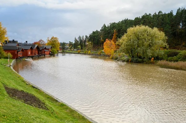 The granite embankment with red houses and barns. White bill boa — Stock Photo, Image