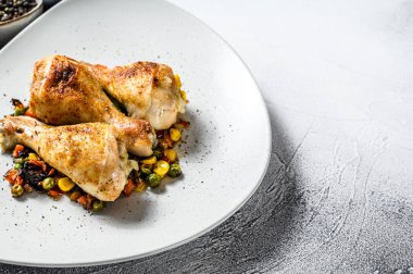 Beyaz tabakta sebzeli ızgara tavuk budu. Beyaz arka plan. Üst Manzara. Boşluğu kopyala.