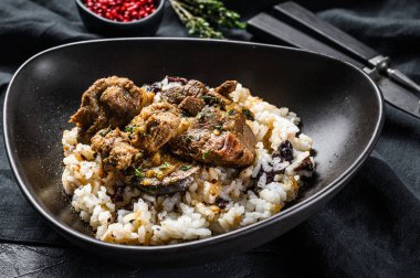 Yunan usulü kuzu güveci, domatesli, pirinçli. Siyah arka plan. Üst görünüm.