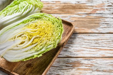 Çin lahanası kesiyorum. Organik sebzeler. Beyaz ahşap arka plan. Üst Manzara. Boşluğu kopyala.