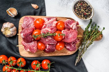 Çiğ şiş kebap. Domates ve baharatlı barbekü eti. Gri arka plan. Üst görünüm.