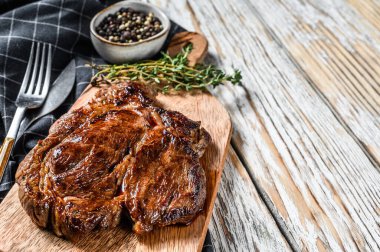 Biftek ızgara. Kesme tahtasında Chuck 'ın gözleri yuvarlanıyor. Beyaz arka plan. Üst Manzara. Boşluğu kopyala.