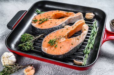 Tavada somon fileto biftek. Çiğ taze balık. Beyaz arka plan. Üst görünüm.