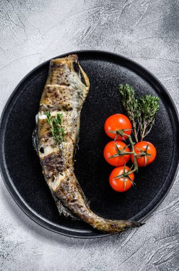 Taze kekik ve domatesli leziz ızgara hake. Siyah arka plan. Üst görünüm.