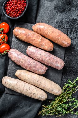 Baharatlı taze domuz eti, sığır eti ve tavuk sosisi. Siyah arka plan. Üst görünüm.