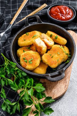 Ev yapımı tavuk nugget ve tavada ketçap sosu. Gri arka plan. Üst görünüm.