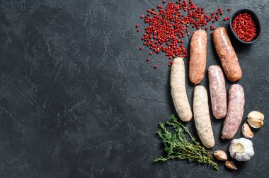 Kekik, sarımsak ve biberle çeşitli taze sosisler. Siyah arka plan. Üst Manzara. Boşluğu kopyala.