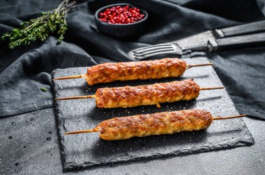 Lula kebabı. Çubukta şiş kebap, kıymalı kıymadan. Siyah arka plan. Üst görünüm.