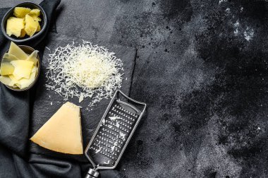 İtalyan sert parmesan peyniri dilimi, kesilmiş, rendelenmiş. Siyah arka plan. Üst Manzara. Boşluğu kopyala.