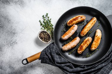 Izgara domuz eti, sığır eti ve tavada baharatlı tavuk sosisi. Gri arka plan. Üst Manzara. Boşluğu kopyala.