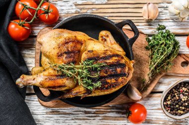 Kekikle bütün çiftlik tavuğunu pişirdim. Beyaz arka plan. Üst görünüm.