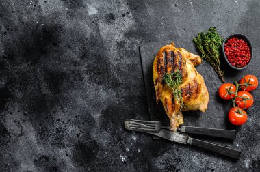 Kekikli ızgara organik tavuk. Siyah arka plan. Üst Manzara. Boşluğu kopyala.