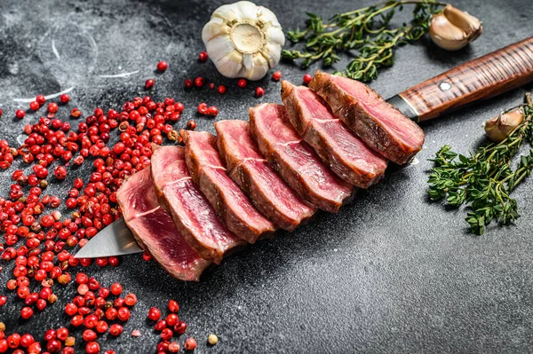 Sliced Grilled Top Blade steak. Organic beef meat. Black background. Top view