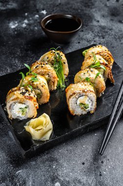 Füme yılan balığı ve salatalıklı suşi rulosu. Siyah arka plan. Üst görünüm.
