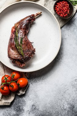 Kızarmış tavşan bacağı ve şifalı otlar. Tekstil peçetesinde servis ediliyor. Organik çiftlik eti. Üst Manzara. Metin için boşluk.