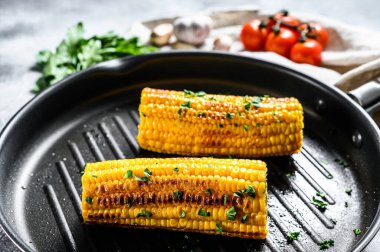 Kızartma tavasında organik ızgara mısır. Organik çiftlik sebzeleri. Gri arka plan. Üst görünüm.