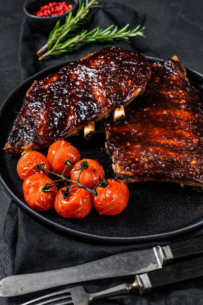Roasted sliced barbecue pork ribs. Barbecue meat. Black background. Top view.