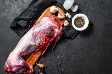 Tüm orman yaban tavşanı, ahşap güvertede çiğ et, eski siyah kırsal masa. Üst görünüm, boşluk kopyala.