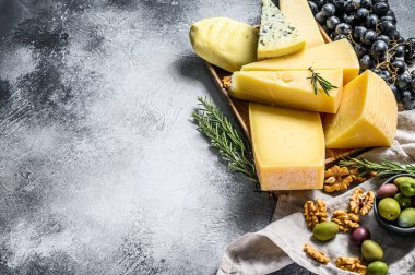 Üzüm, kraker, zeytin ve fındık ile servis edilen peynir tabağı. Çeşit çeşit lezzetli atıştırmalıklar. Gri arka plan. Üst Manzara. Metin için boşluk.