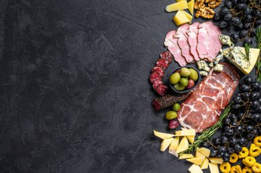 Prosciutto, jambon, peynir ve zeytinli tipik İtalyan antipasto. Siyah arka plan. Üst Manzara. Metin için boşluk.