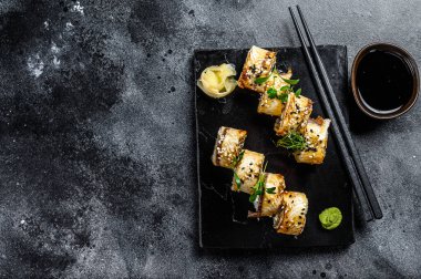 Füme yılan balığı ve salatalıklı suşi rulosu. Siyah arka plan. Üst Manzara. Boşluğu kopyala.