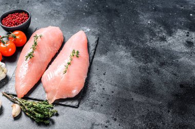 Çiğ hindi bifteği. Göğüs filetosu. Siyah arka plan. Üst Manzara. Boşluğu kopyala.