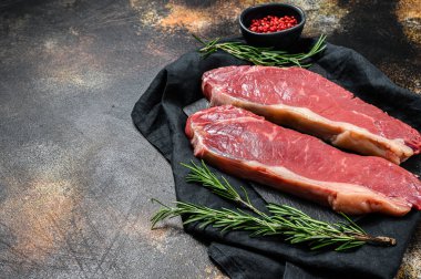 Çiğ biftek, taze et, mermer sığır eti. Karanlık arka plan. Düz yatıyordu.