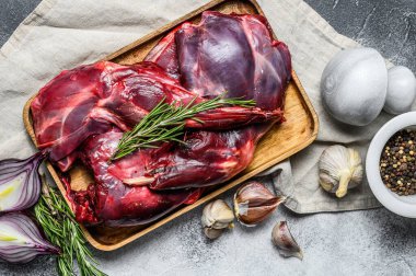 Tavşan eti. Tahta bir masada çiğ yaban tavşanı ve sebze ve baharatlar. Üst Manzara. Organik et.