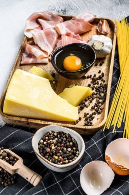 Geleneksel İtalyan Carbonara Makarnası. Pastırma, spagetti, parmesan peyniri ve pekorino peyniri, yumurta, sarımsak. Gri arka plan. Üst görünüm.