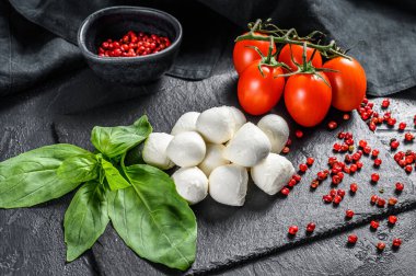 Mini mozzarella peyniri, fesleğen yaprağı ve vişneli domates, Caprese salatası. Siyah arka plan. en üstteki görünüm.