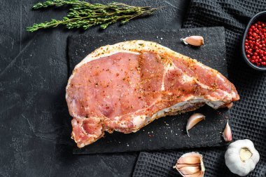 Bitki ve baharatlı çiğ et. Salamura domuz bifteği. Yemek yapmak için gerekli malzemeler. Siyah arka plan. Üst görünüm