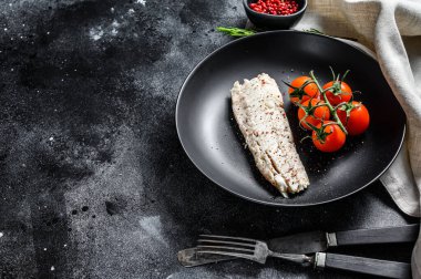 Çeri domatesli mezgit fileto. Siyah arka plan. Üst Manzara. Boşluğu kopyala.