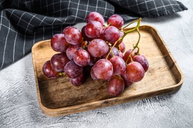 Tahta bir kasede olgun kırmızı üzümler. Beyaz arka plan. Üst görünüm.