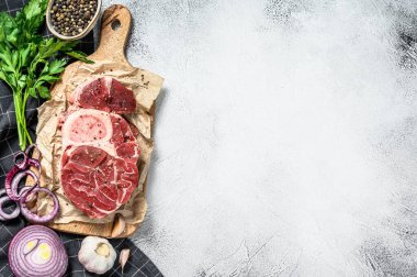 Çiğ dana şişi, Osso Buco baharat ve bitkilerle. OssoBuco eti. Gri arka plan. Üst Manzara. Boşluğu kopyala.