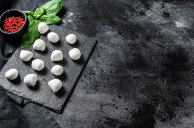 Mini mozarella peyniri topları, Caprese salatası için malzemeler. Siyah arka plan. Üst Manzara. Boşluğu kopyala.