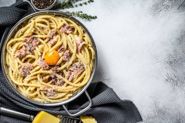 Carbonara usulü makarna, tavada bucatini. Gri arka plan. Üst Manzara. Boşluğu kopyala.