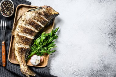 Izgara mezgit balığı pişiriyorum. Gri arka plan. Üst Manzara. Boşluğu kopyala.