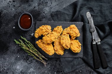 Baharatlı Kızarmış Tavuk Kanatları. Siyah arka plan. Üst görünüm.