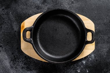 Karanlık arka planda boş dökme demir tava. Üst Manzara. Boşluğu kopyala.