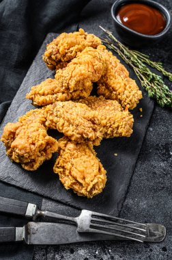 Baharatlı Kızarmış Tavuk Kanatları. Siyah arka plan. Üst görünüm.